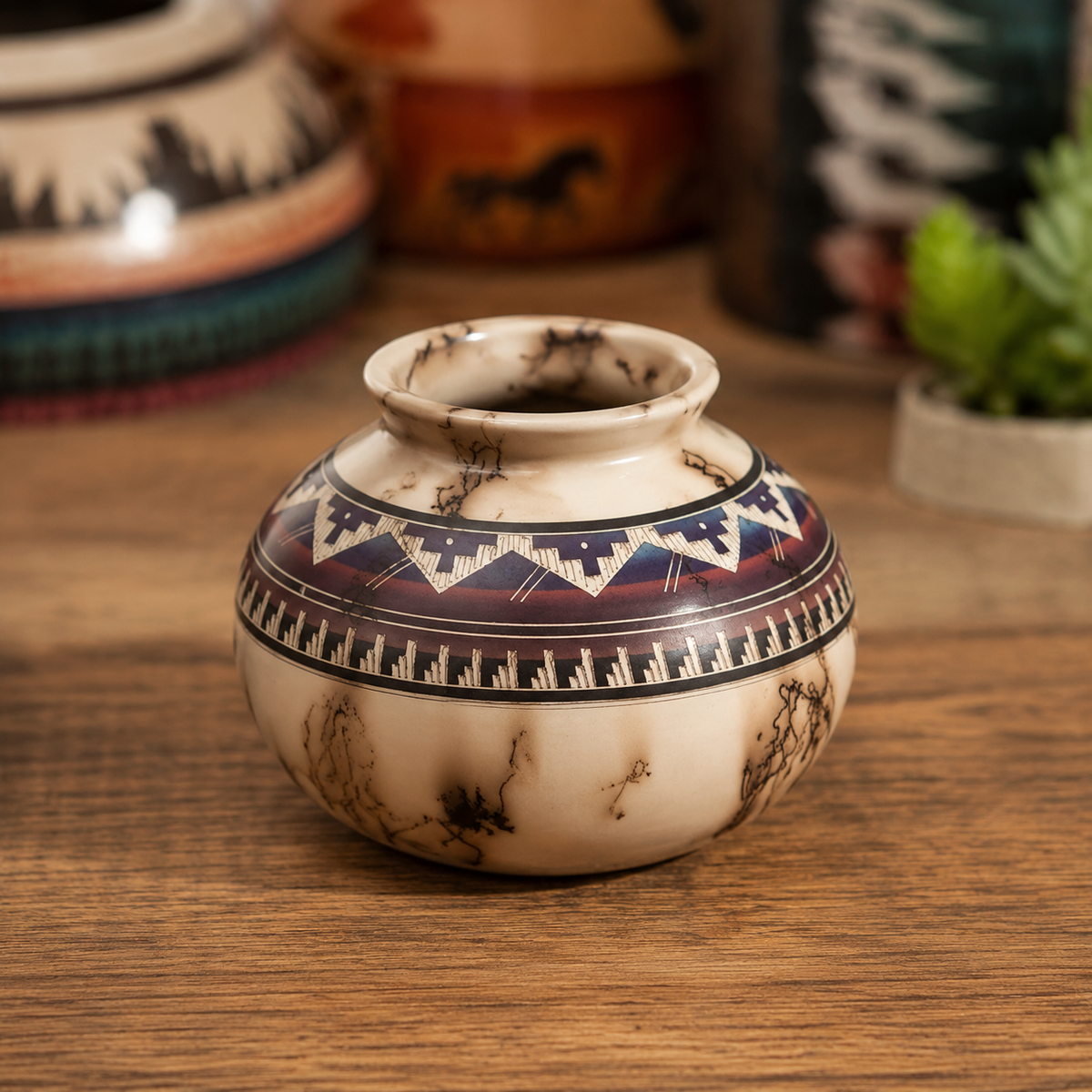 Decorative ceramic pot with tribal patterns on a wooden surface