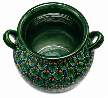 Decorative green ceramic pot with leaf pattern on a white background