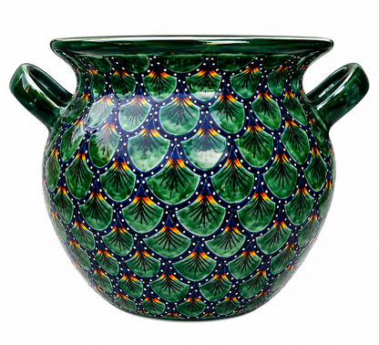 Ceramic pot with green scale-like pattern on a white background