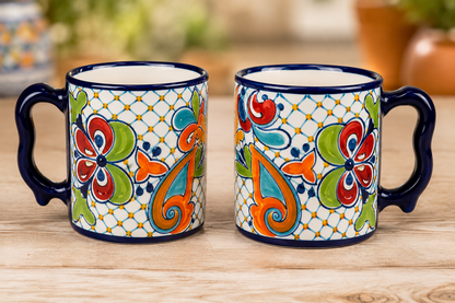 Two colorful mugs with floral patterns on a wooden surface.